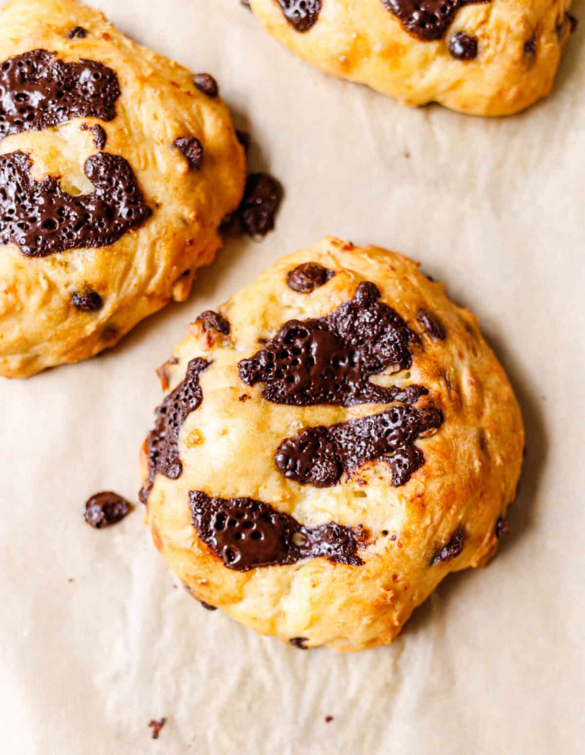 Two chocolate chip cottage cheese scones cooling on parchment paper
