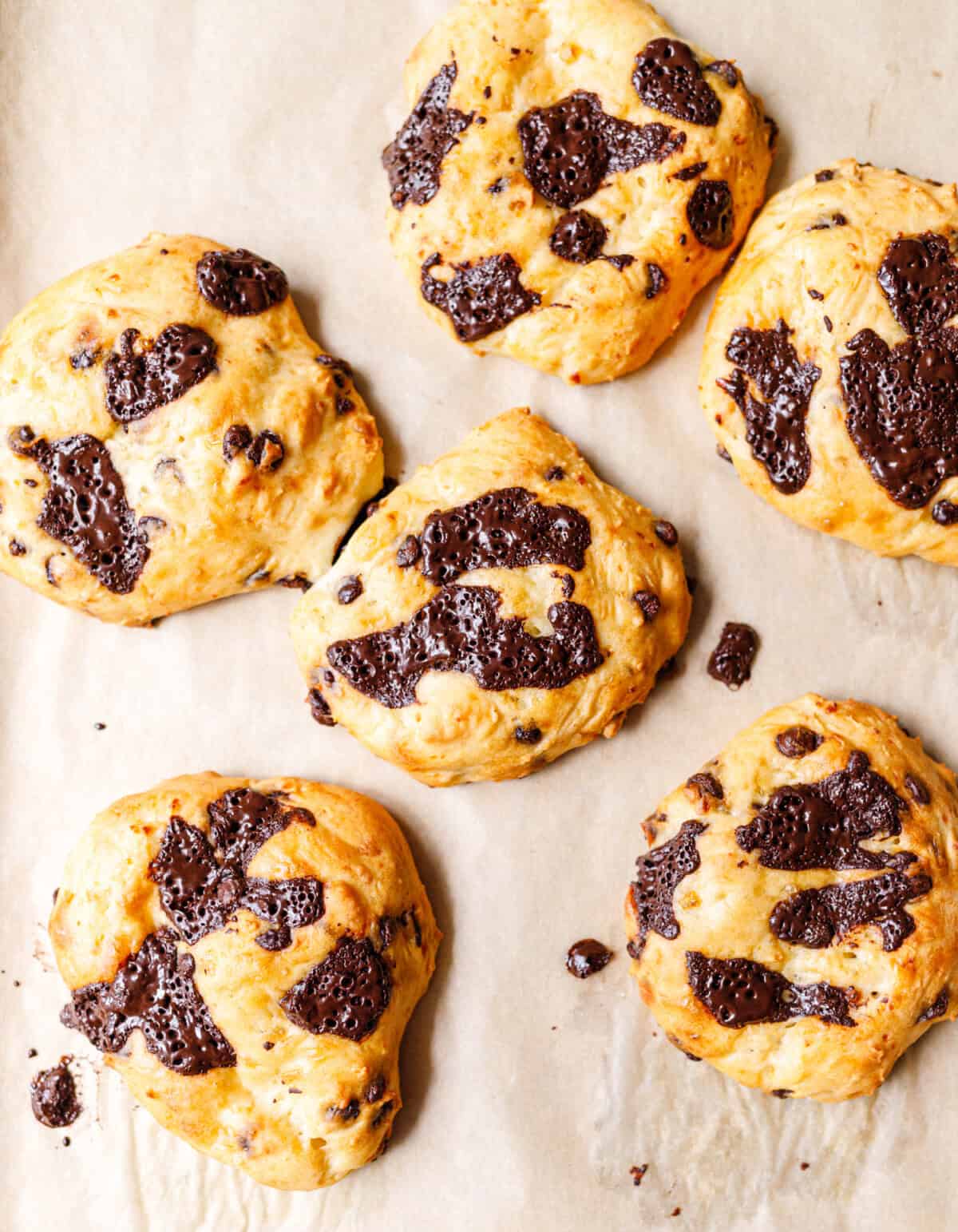Six baked cottage cheese drop scones spaced on a parchment lined baking sheet