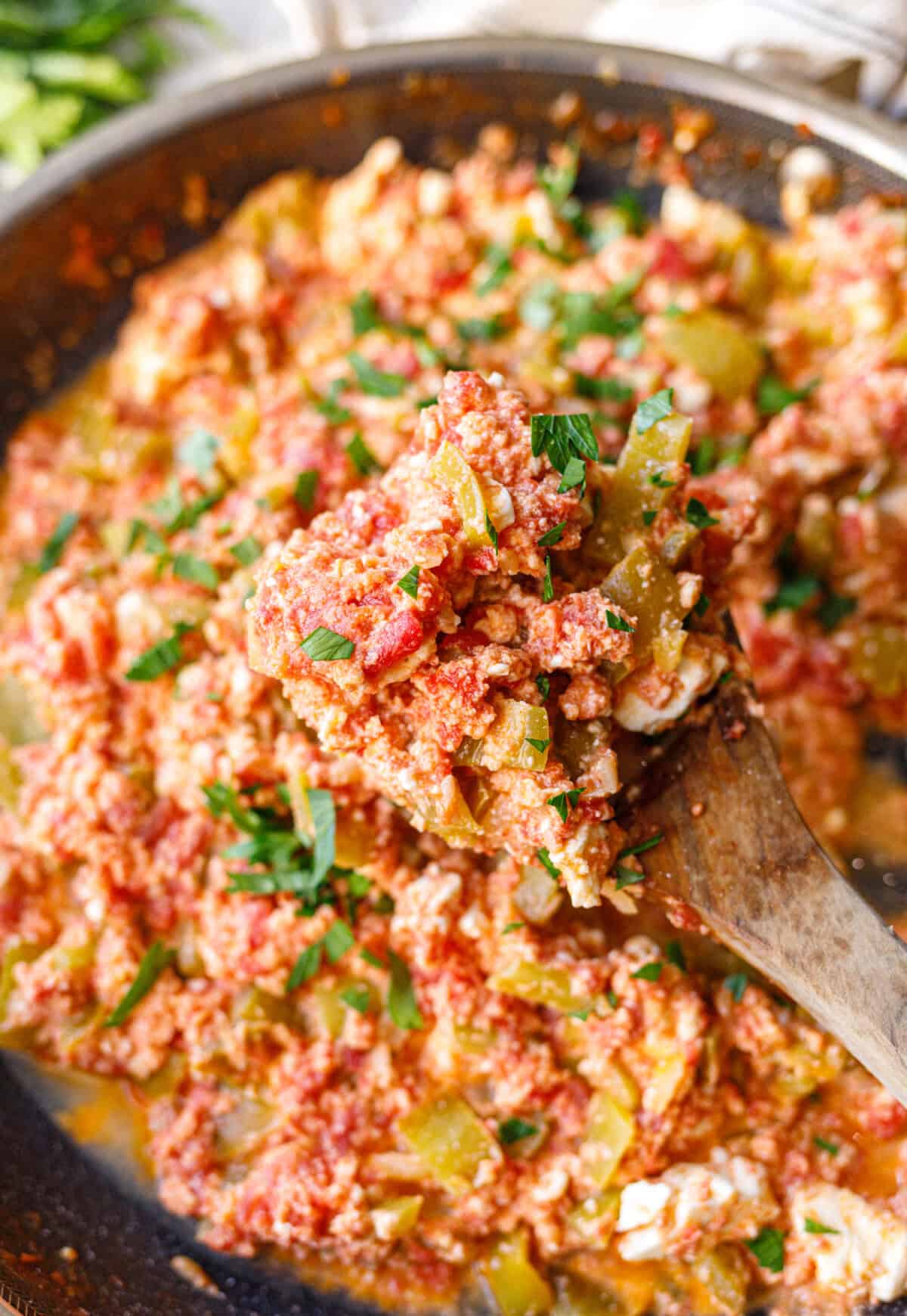 Close-up of Bulgarian mish mash showing soft eggs, green peppers and crumbled feta