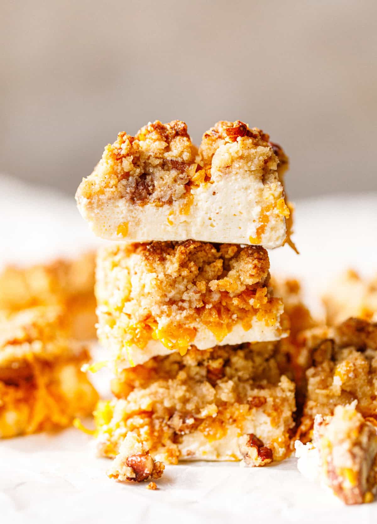 Three sugar-free pumpkin bars stacked high, with the top bar showing a thick white skyr layer under a golden crumb topping