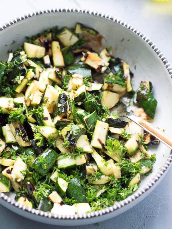 A bowl full of mouthwatering chopped grilled zucchini pieces, topped with fresh chopped parsley, dill, garlic, balsamic, apple cider vinegar and olive oil. Gread side dish for grilled meat, chicken or fish.