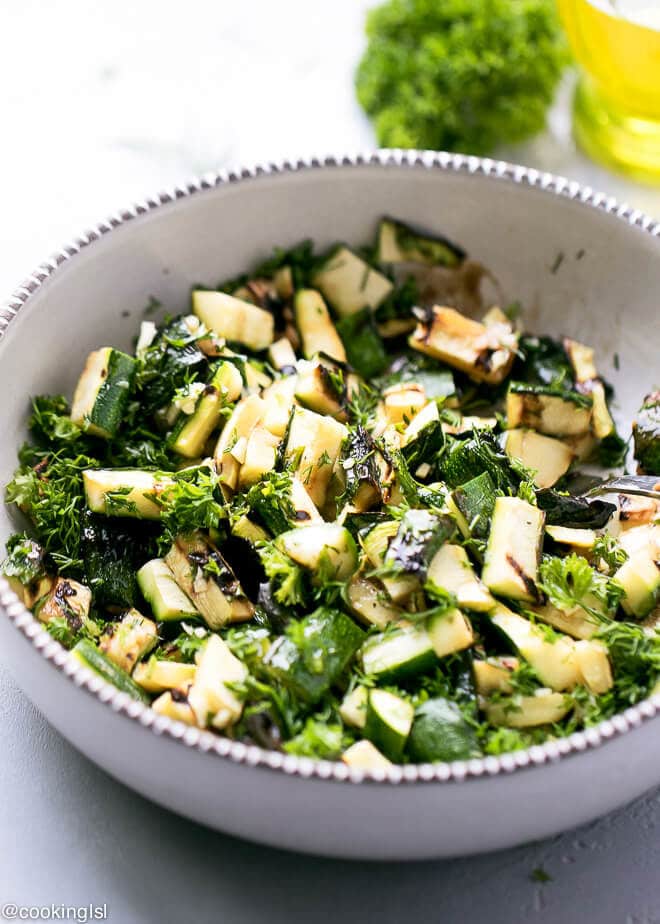 A bowl full with chopped grilled zucchini salad, with olive oil, venegar, balsamic, garlic, parsley and dill dressing. Fresh, great for chicken or fish side dish.