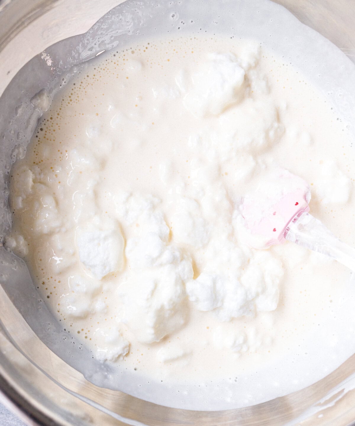 Folding whipped egg whites into the yogurt mixture for no bake yogurt cake