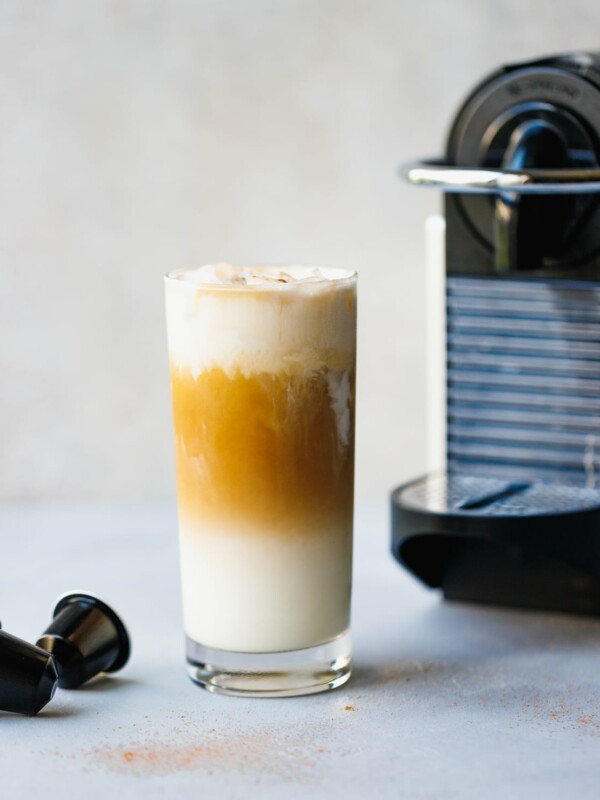 Iced Vanilla Coffee Latte Recipe Using Nespresso in a glass with coffeemaker next to it