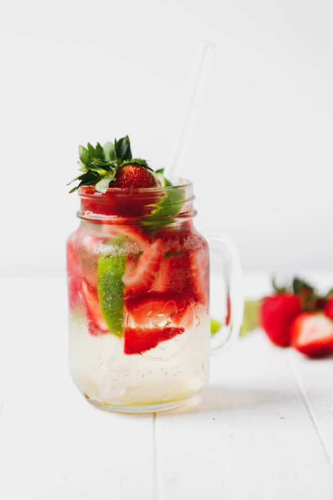 Strawberry mojito in a glass jar with a clear straw