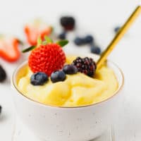 Homemade custard in a white bowl topped with berries