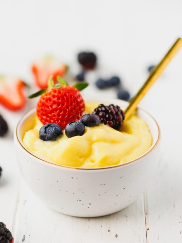 Homemade custard in a white bowl topped with berries