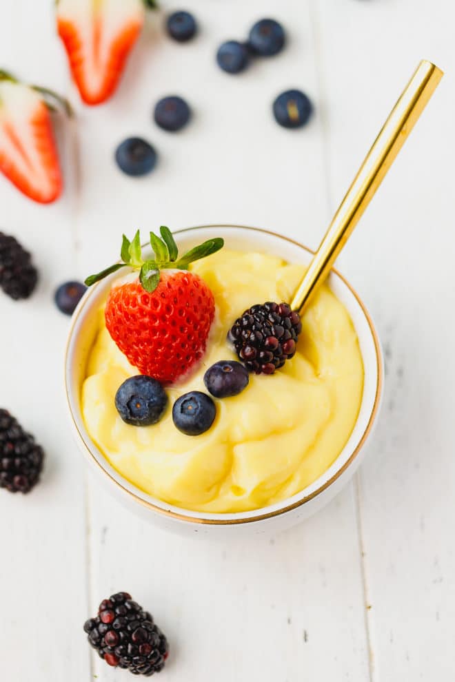 Custard in a bowl topped with berries