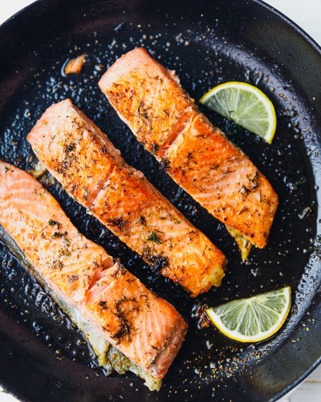 Easy pan seared salmon in a cast iron skillet with lemon slices