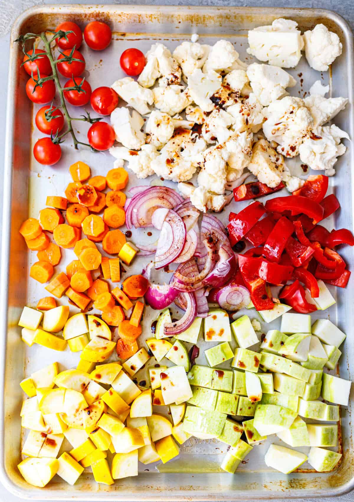 Chopped vegetables on a sheet pan drizzled with balsamic before grilling or roasting