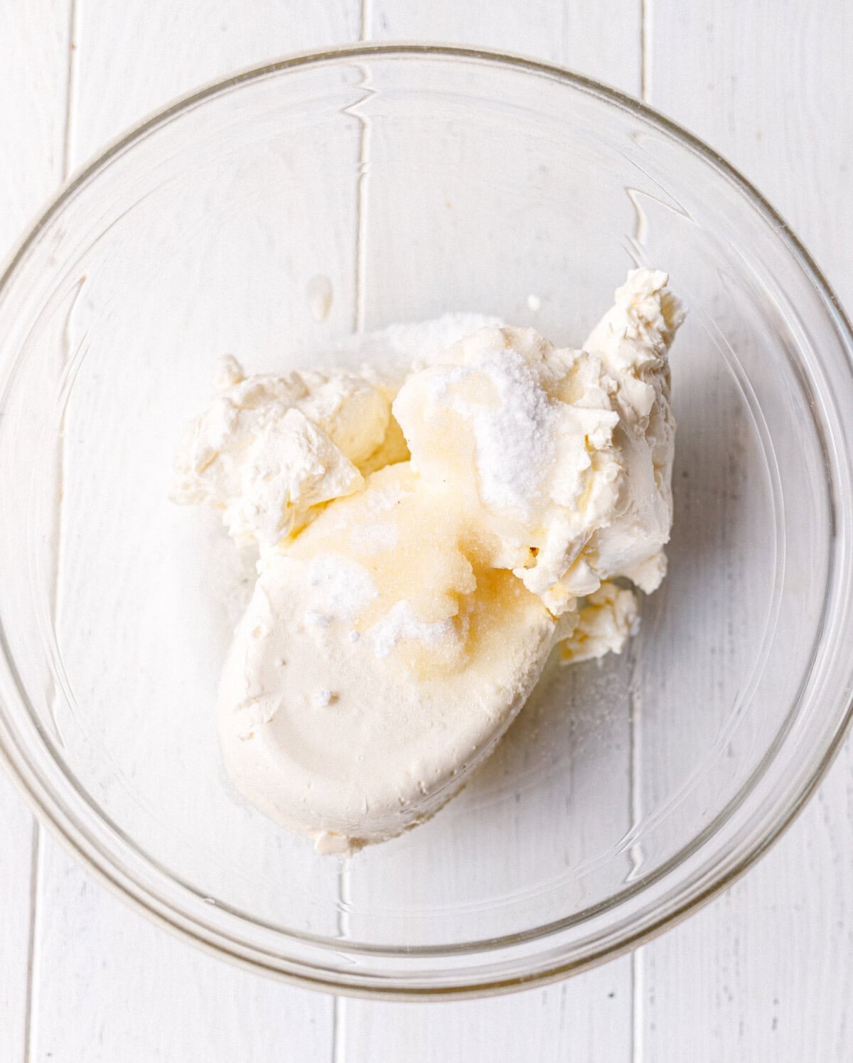 Two softened blocks of cream cheese in a glass bowl ready to be beaten