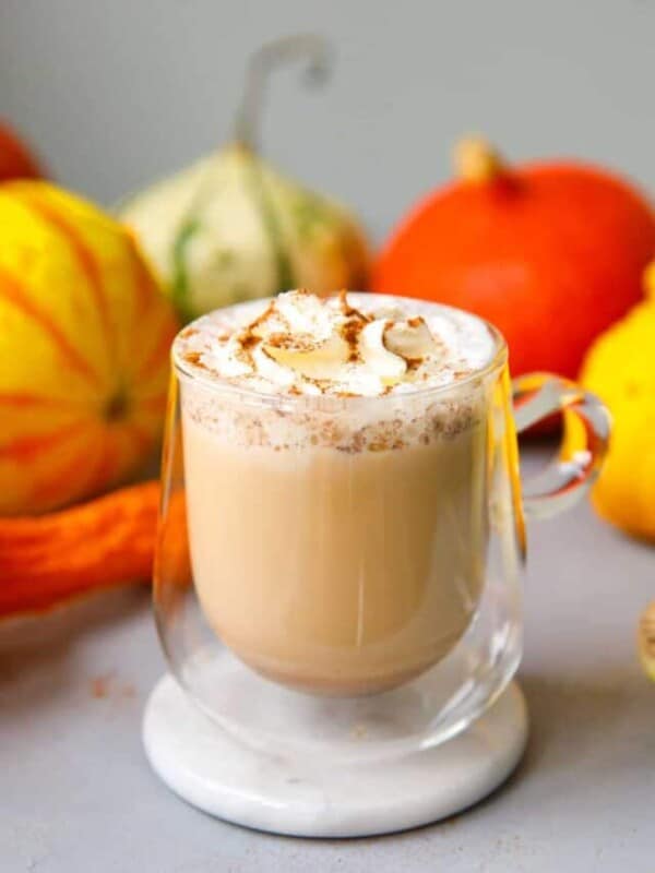A clear glass with homemade pumpkin spice latte and whipped cream