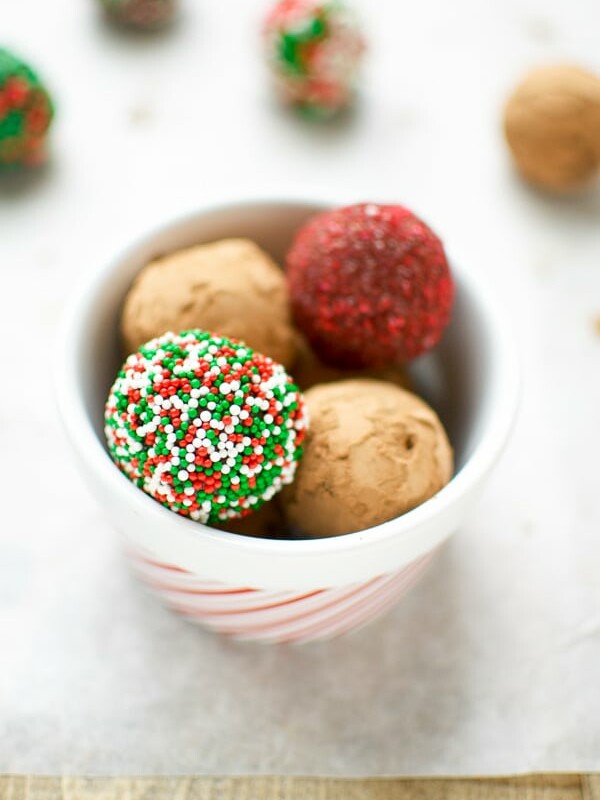 Raw Date And Orange Christmas Truffles. Healthy, vegan and gluten free, Christmas truffles in a bowl, with white, red and green sprinkles.