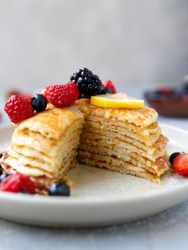 A plate with lemon cottage cheese pancakes, topped with berries