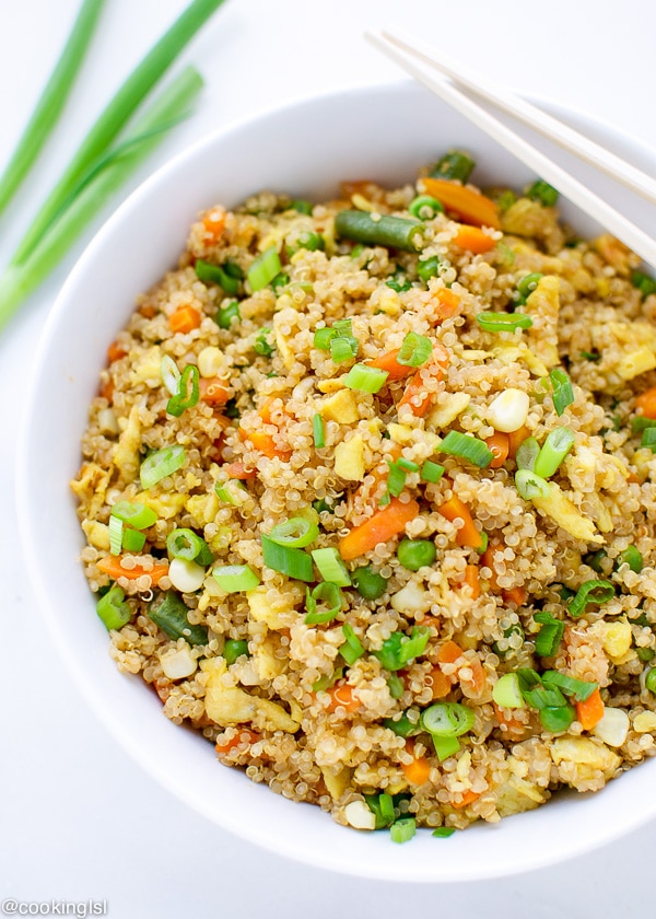 EASY QUINOA FRIED RICE in a white bowl, with scallions on the side.