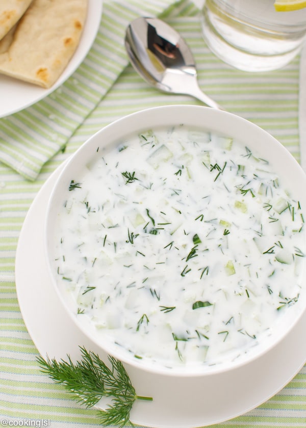 A bowl of chilled and energizing, fresh Bulgarian Cucumber yogurt soup- Tarator. Summer favorite. Served with bread and dill.