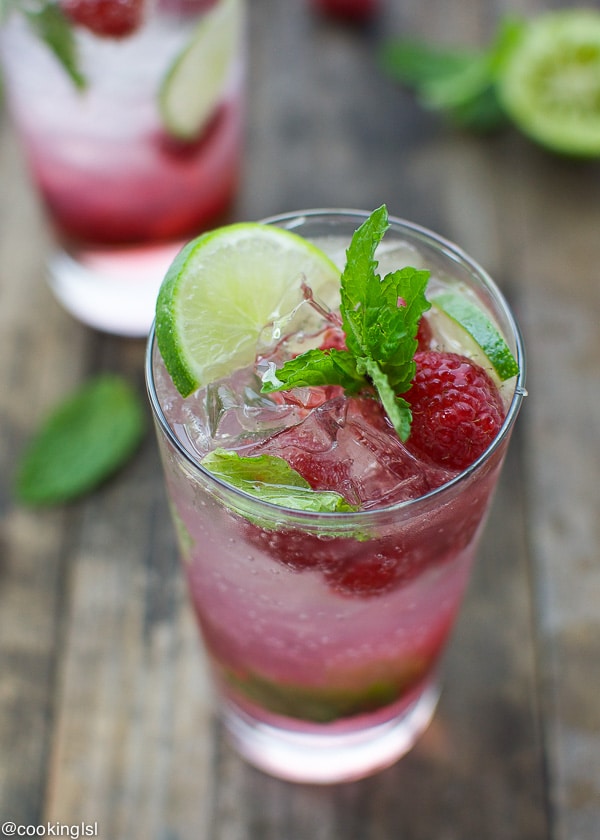 Raspberry mojito cocktail in a glass with lime