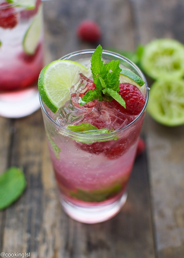 Sparkling raspberry mojito in a tall glass with mint on top