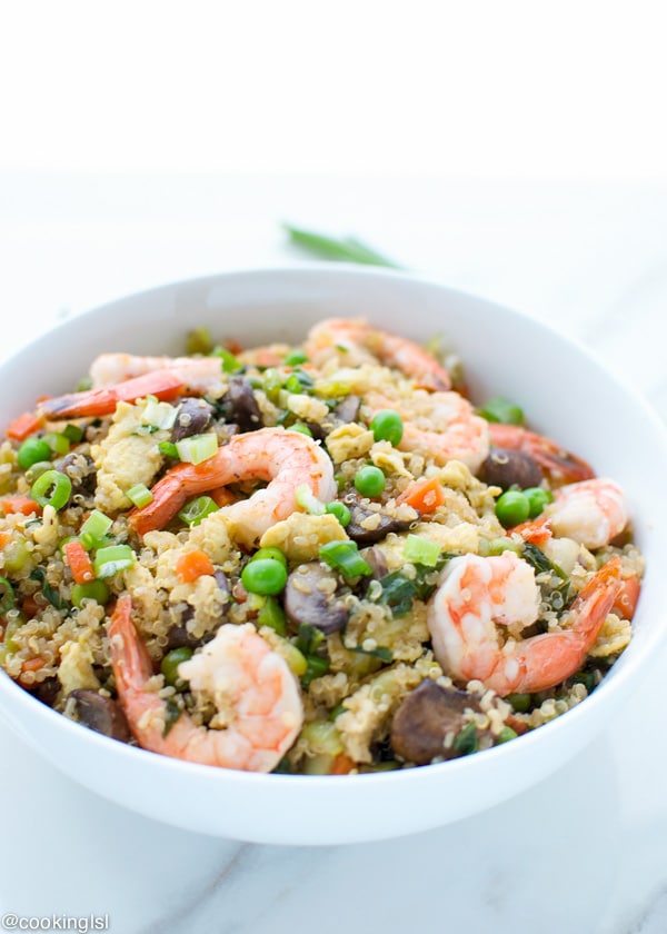 A bowl with chunky and hearty shrimp fried rice, made with quinoa, mushrooms and bok choy.
