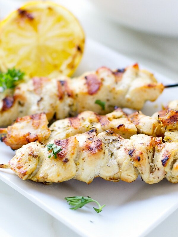 Chicken Skewers With Cabbage Slaw on a white plate, juicy, with lemon wedge