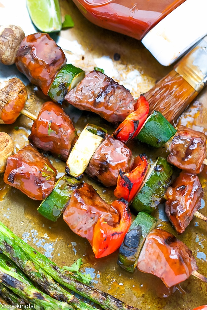 Tender beef kebabs, beef kabobs with tangy Heinz barbecue sauce. Served on a tray with grilled veggies. Skewered on wooden skewers with zucchini, mushrooms and peppers.