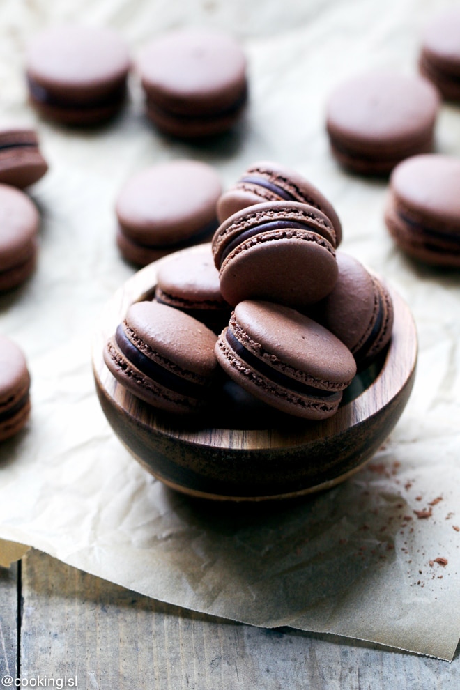 Chocolate French macarons in a small wooden bowl