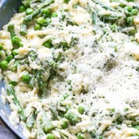 A skilled filled with cooked orzo, fresh spring veggies - asparagus, peas, Parmesan and creamy healthy sauce.