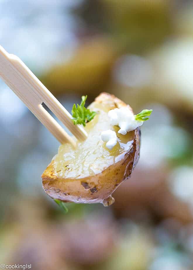 grilled potato appetizer Greek Style with feta and small wooden fork for a grilling party