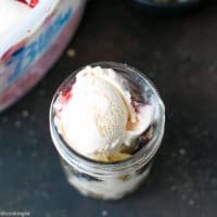 Cherry Sundae Recipe - step by step photos. Mason Jar with crushed cookies, Blue Bunny® Ice cream, fresh cherries, coconut and chopped almonds.