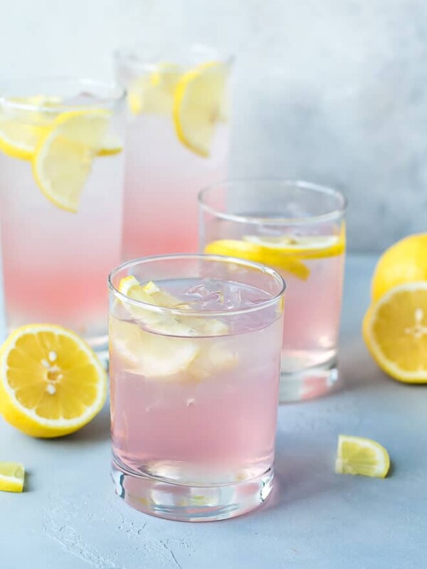 Glassed filled with pink vodka cocktail, perfect for summer parties. Pink Lemonade Vodka Cocktail Recipe-easy to make, made with KINKY Pink Liqueur. Glasses filled with ice , pink lemonade vodka and lemon slices.