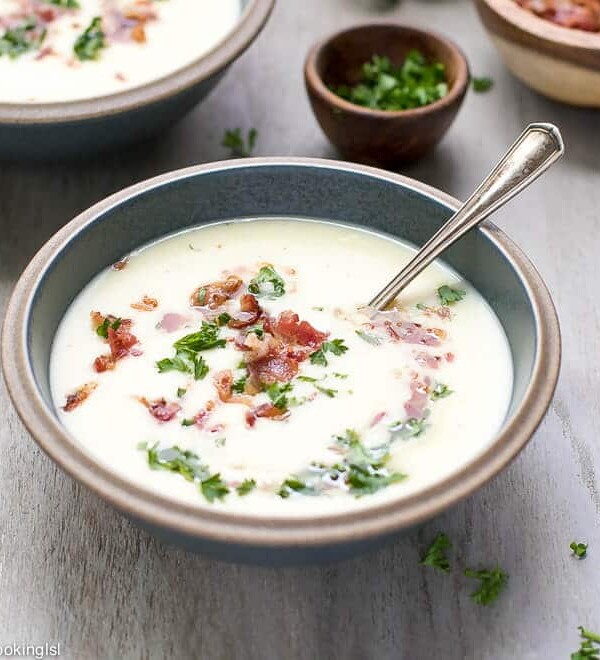 A creamic bowl full with warm and comforting Creamy Leek And Potato Soup With Bacon Recipe.