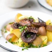 A plate with warm octopus and potato salad. Grilled octopus with boiled potatoes recipe