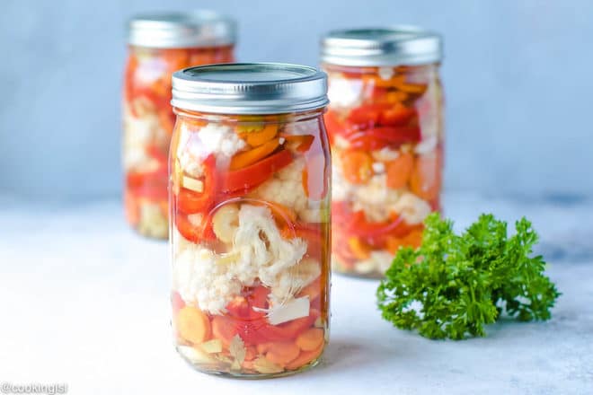 Ball Jars with easy canned vegetables cauliflower, carrots and red peppers recipe. Safe pickling method for crunchy garden vegetables. Healthy, briny and delicious.