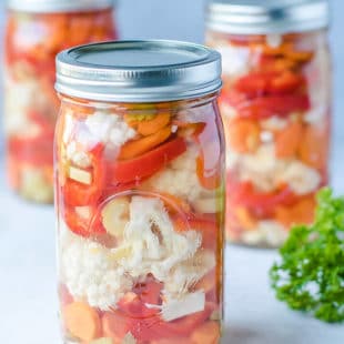 Ball Jars with easy canned vegetables cauliflower, carrots and red peppers recipe. Safe pickling method for crunchy garden vegetables.