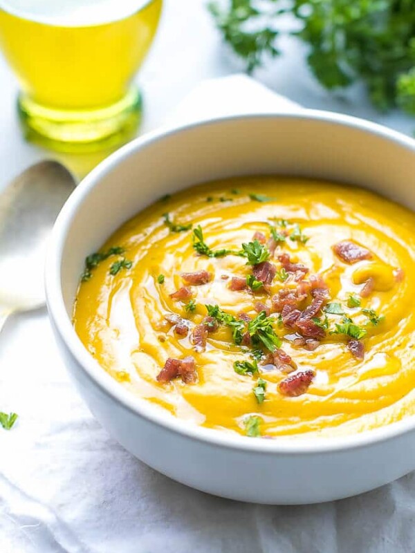 A bowl filled with creamy sweet potato soup. Made with sweet potatoes cooked in the microwave. Topped with bacon bits and parsley.