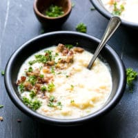 Cauliflower Cheese Soup Low Carb Recipe, Bowl full with cauliflower cheddar soup, topped with chopped parsley and chopped bacon.