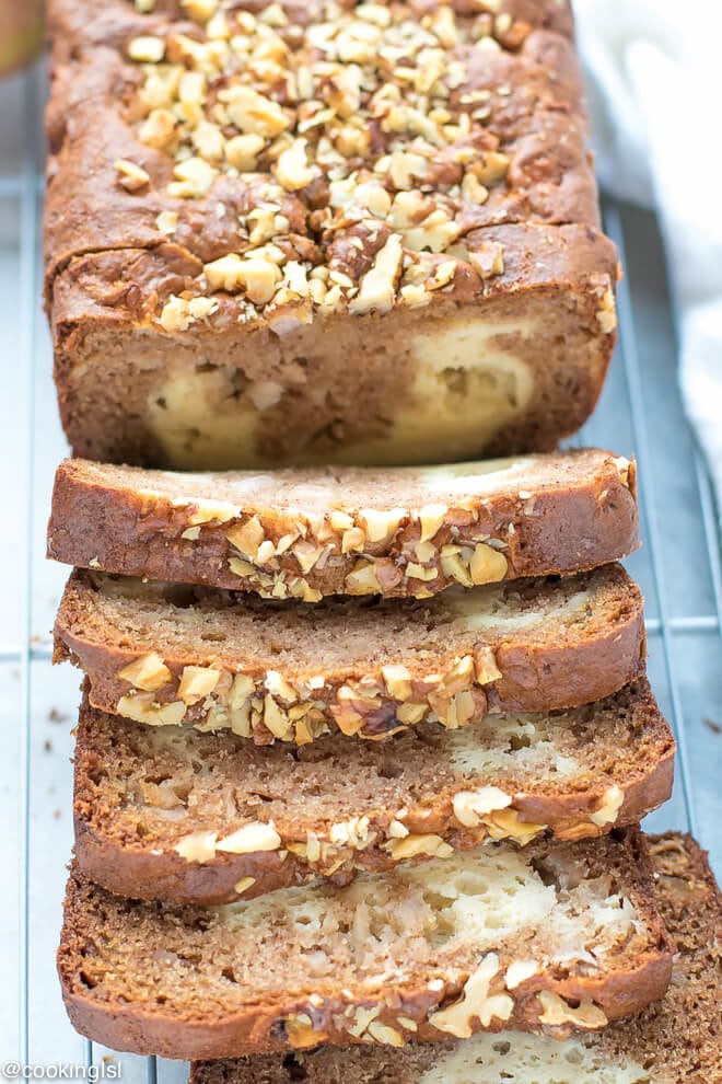Cream Cheese Filled Apple Bread Recipe -slices of moist apple bread on a cutting cooling rack. Topped with walnuts.