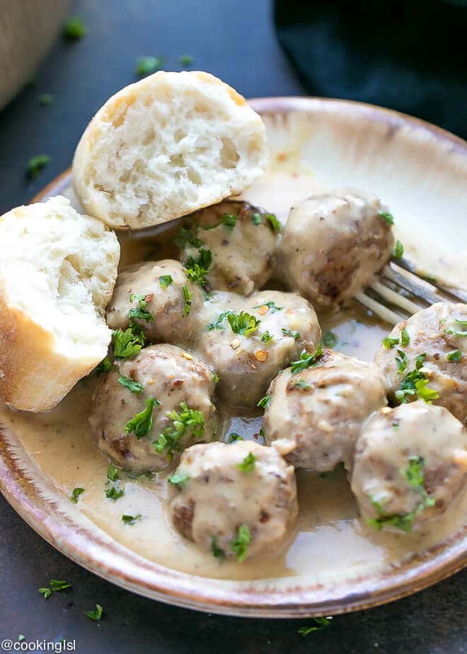 Meatloaf Meatballs With Creamy Sauce Recipe- small meatballs on a pan with a fork and crusty white bread.