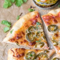 Canned Jalapeno Pizza Recipe - cheesy pizza, thin crust, topped with LA MORENA® Jalapeños and can on the side.