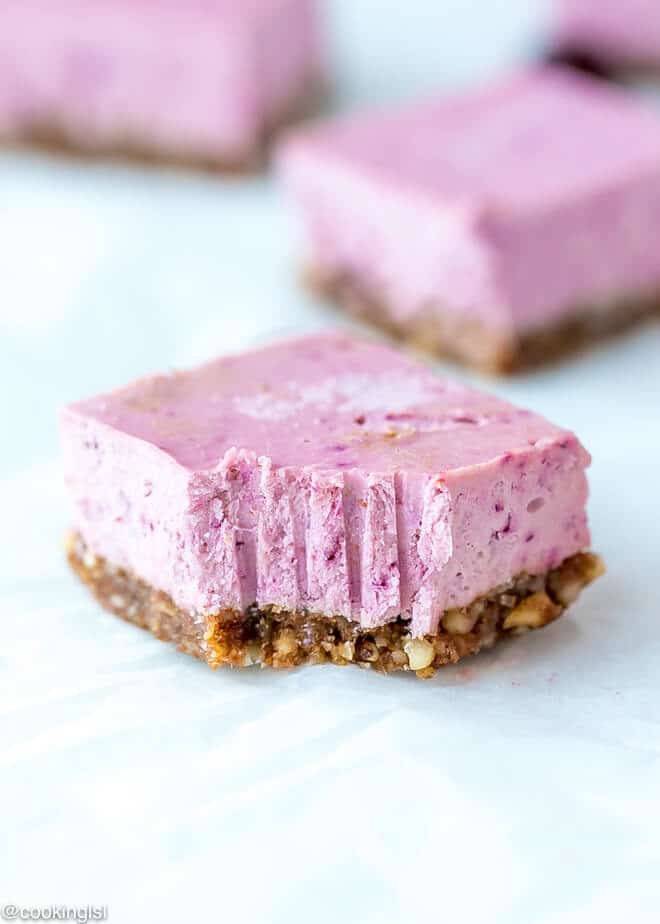 Raw Vegan Cranberry Cheesecake Bars Recipe , a bite taken into a vegan dessert.
