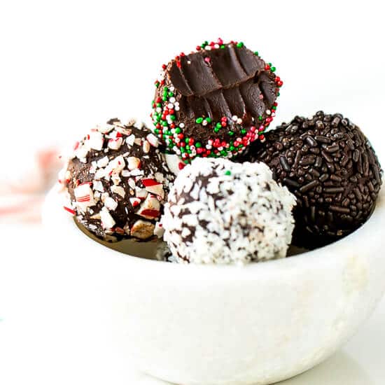 dark chocolate peppermint truffles recipe. A bowl full with Christmas decorated truffles, one truffle taken bite into.