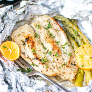 Easy Chicken And Asparagus Foil Packets Recipe topped with lemon, easy to make, served in foil.