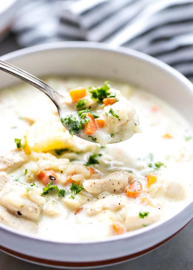 Panera Inspired Easy Cream Of Chicken And Rice Soup in a white ceramic bowl with a soup spoon.
