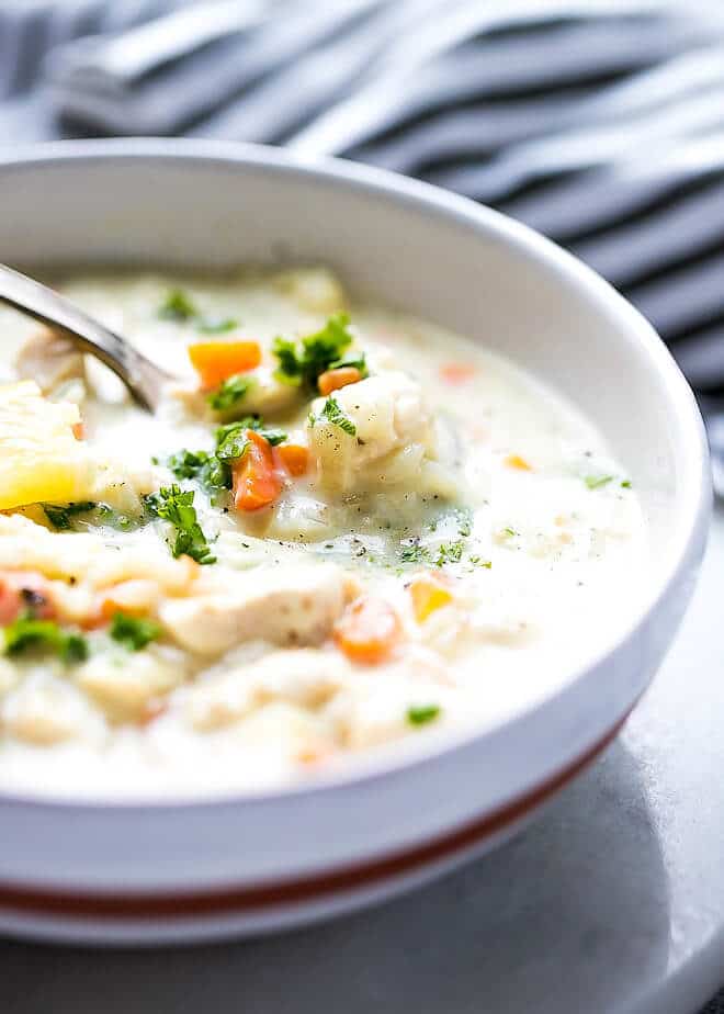 A bowl full of chunky cream of chicken and rice soup