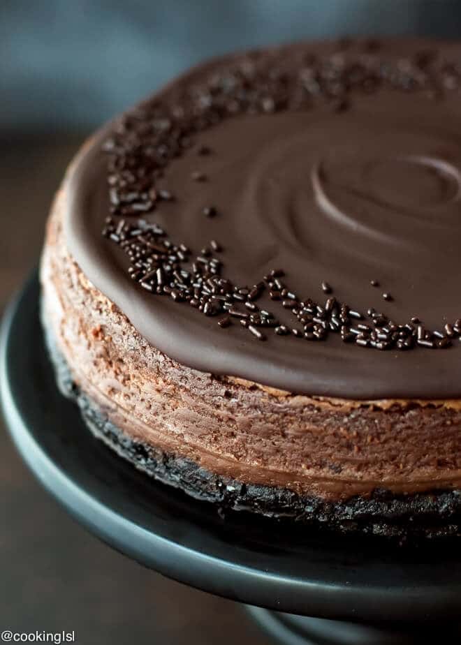 Chocolate Mascarpone Cheesecake Recipe , on a black cake platter, decorated with chocolate sprinkles!