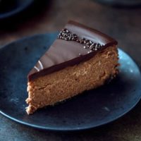 Chocolate mascarpone cheesecake slice on a black plate