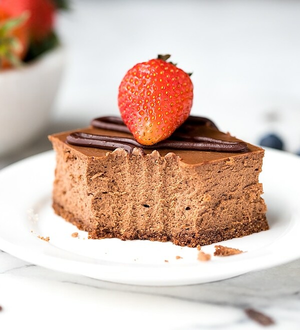 Chocolate Cheesecake Bars Recipe- a square slice of chocolate cheesecake, drizzled with ganache, topped with strawberry