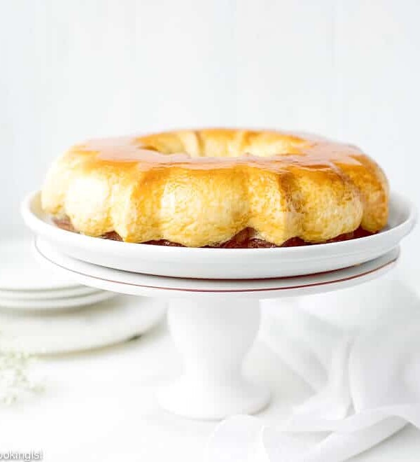 Easy Chocoflan Recipe - Kodrit Kadir. Creme caramel flan in a bundt pan, inverted over a white platter on a cake stand.
