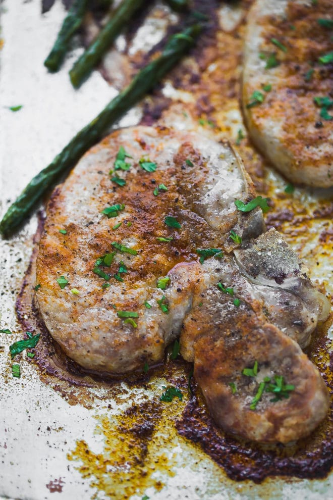 Oven baked bone-in pork chops on a baking sheet