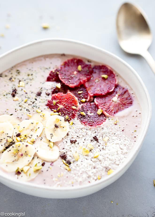 Blood Orange Smoothie Bowl Recipe-thick citrus smoothie in pink color in a bowl, topped with blood orange, bananas, nuts and seeds.